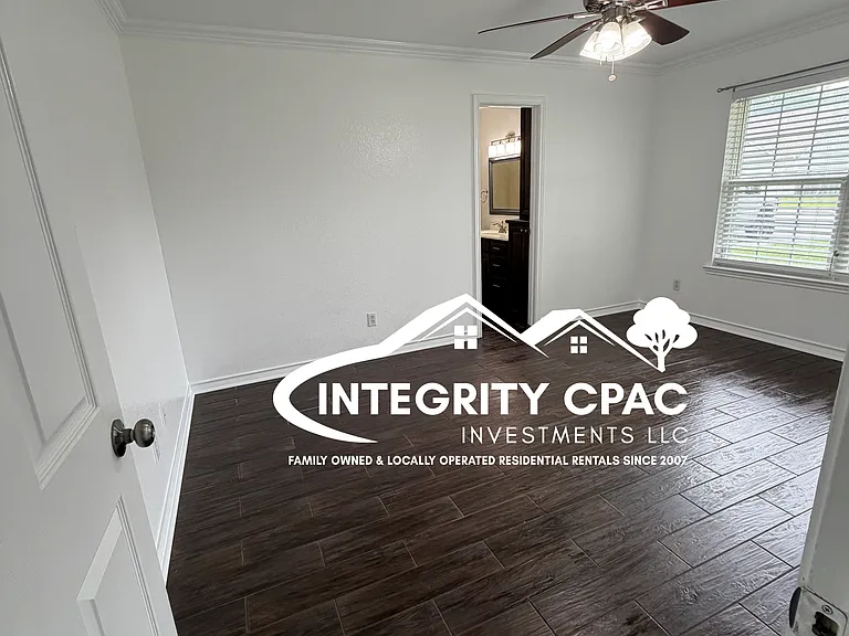 Spacious bedroom with dark wood-looking tile floor 214 Fair, Integrity CPAC LLC