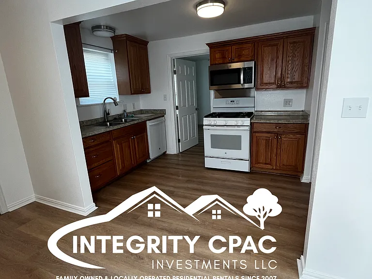 Open kitchen rental home with dark cabinets and white appliances, 1415 Lanius in Gainesville TX by Integrity CPAC